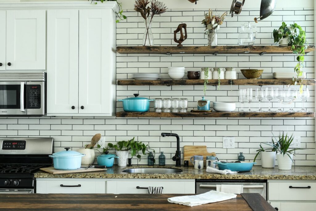 Cocina con armarios blancos y estanterías ordenadas